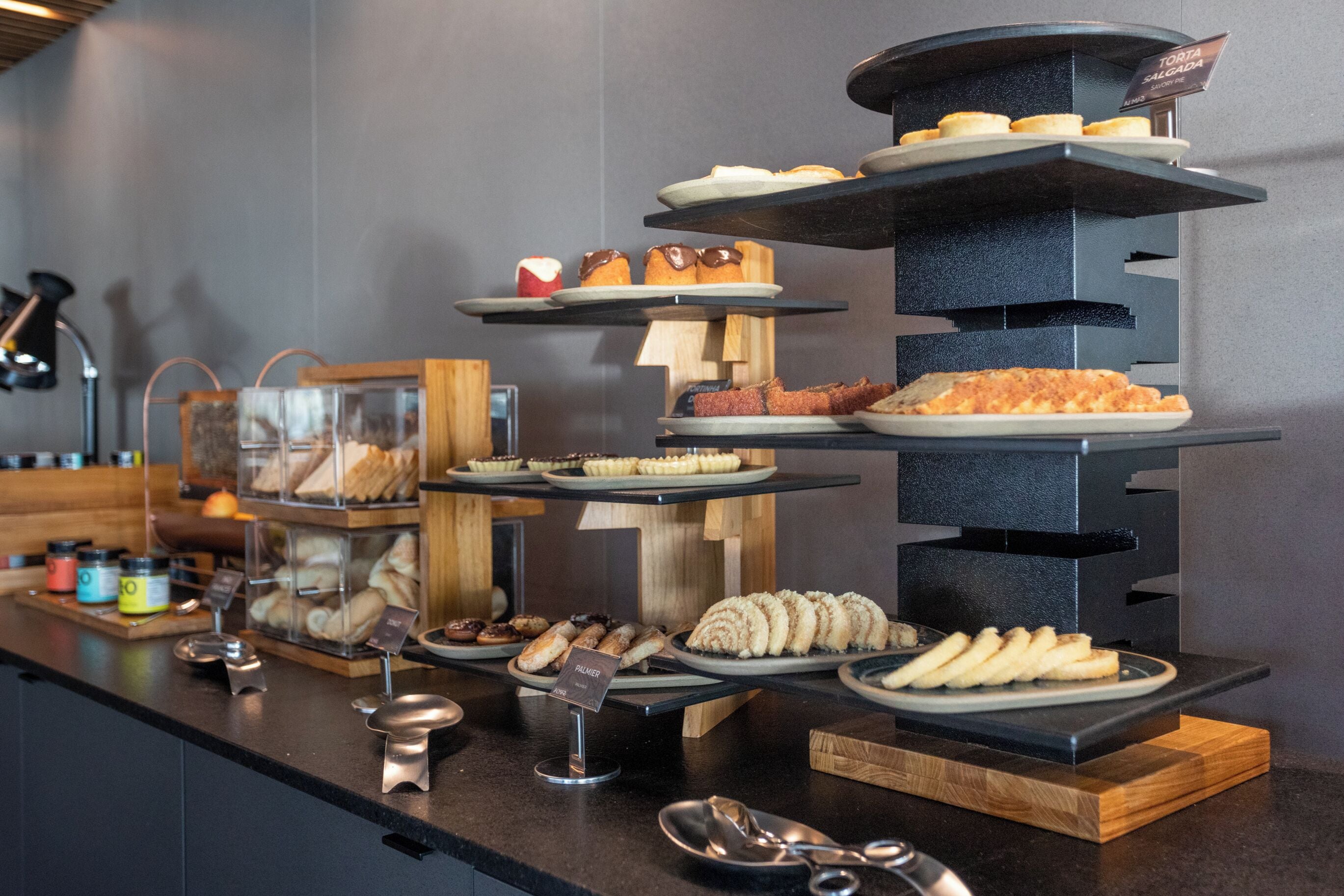 Un buffet proposant une variété de pâtisseries et de desserts présentés sur des présentoirs à étages.
