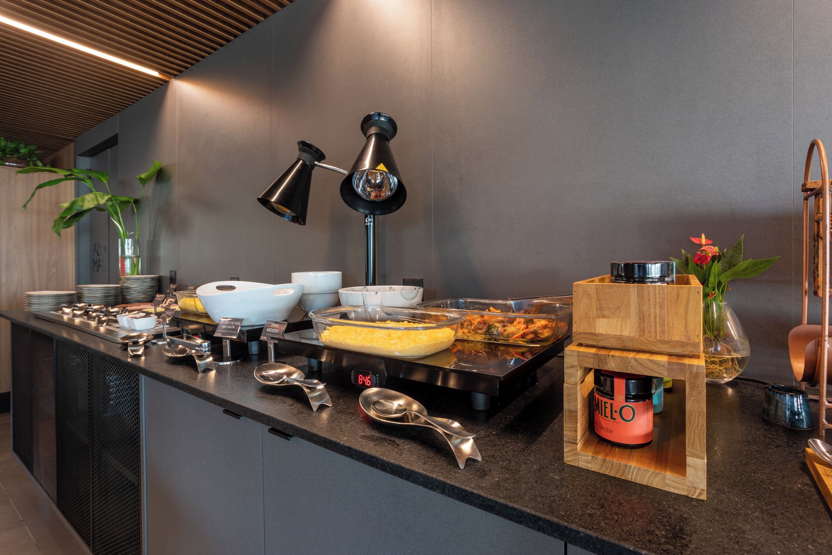 En buffetopstilling med forskellige retter, en kaffemaskine og et ur.