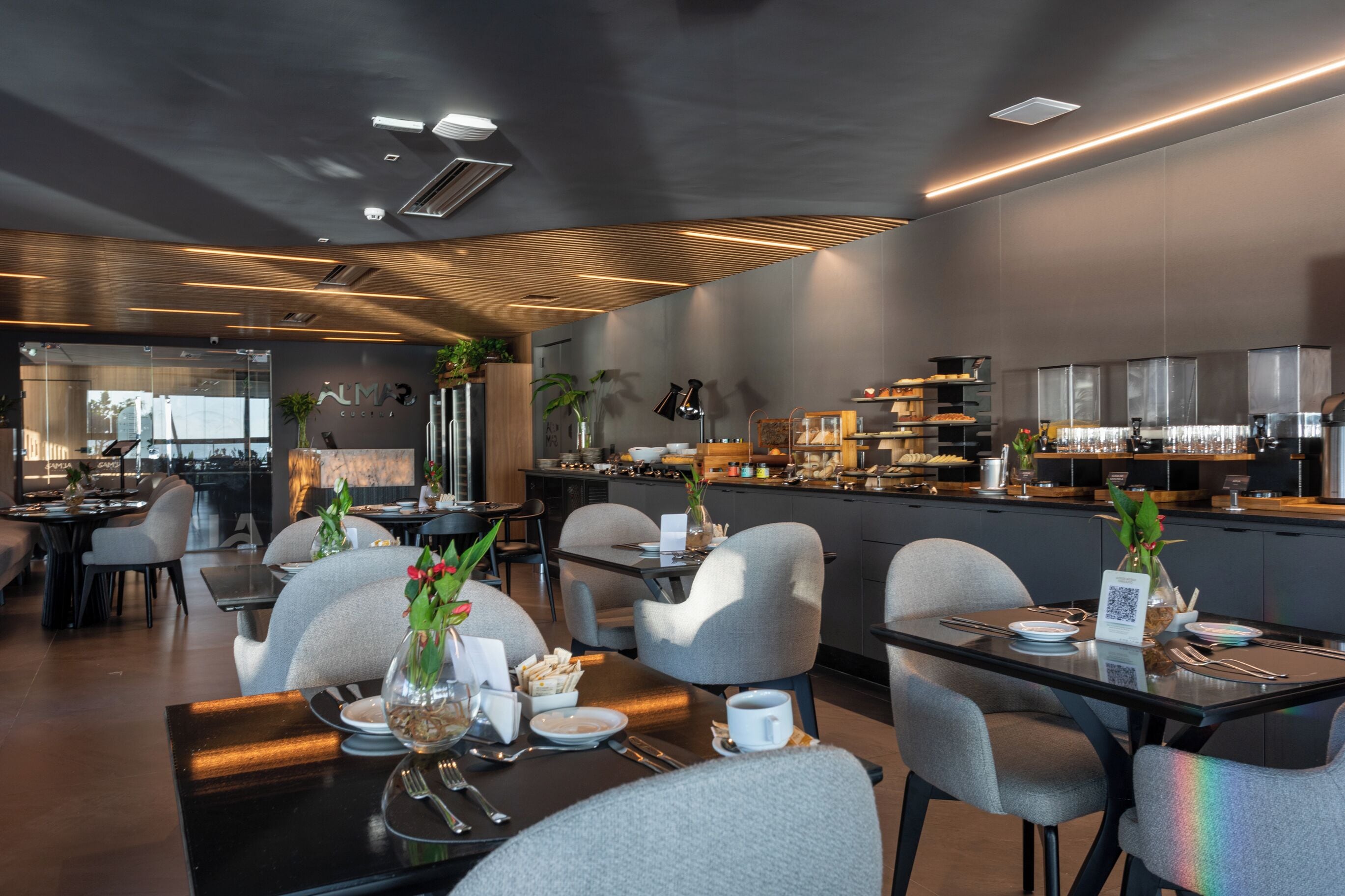 Un restaurante moderno con comedor, cocina y zona de bar/salón.
