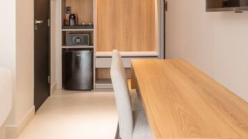Una cocina moderna con una mesa y sillas de madera, electrodomésticos integrados y un televisor fijado a la pared.