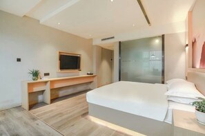 A modern bedroom with a bed, a TV mounted on the wall, a desk, and a glass partition. - Guangzhou Jiulong Hotel (Sansui Fuzheng West Road Branch) (Sansui)