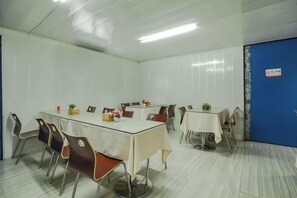 A conference room with a large table, chairs, and a blue door. - Guangzhou Jiulong Hotel (Sansui Fuzheng West Road Branch) (Sansui)
