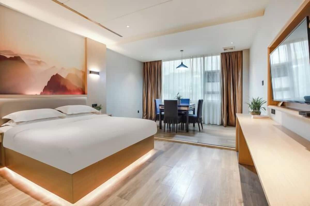 Een moderne hotelkamer met een groot bed, een bureau en een zithoek.
