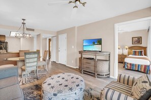 A spacious living area with a television, a dining table, and a comfortable seating arrangement.