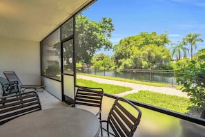A balcony with a view of a park and a body of water.