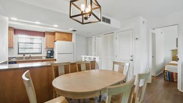 Una cocina moderna con una isla central, armarios de madera y una lámpara colgante.