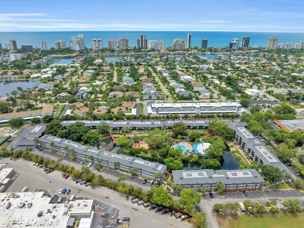 A residential area with a large building complex, a marina, and a view of the ocean.