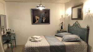 A bedroom with a bed, a dresser, a nightstand, a mirror, and a painting on the wall. - Apartment LA BASTIDE (Rosières, Haute-Loire)