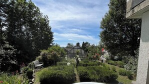 An outdoor inflatable pool surrounded by lush greenery and a garden path. - Apartment LA BASTIDE (Rosières, Haute-Loire)