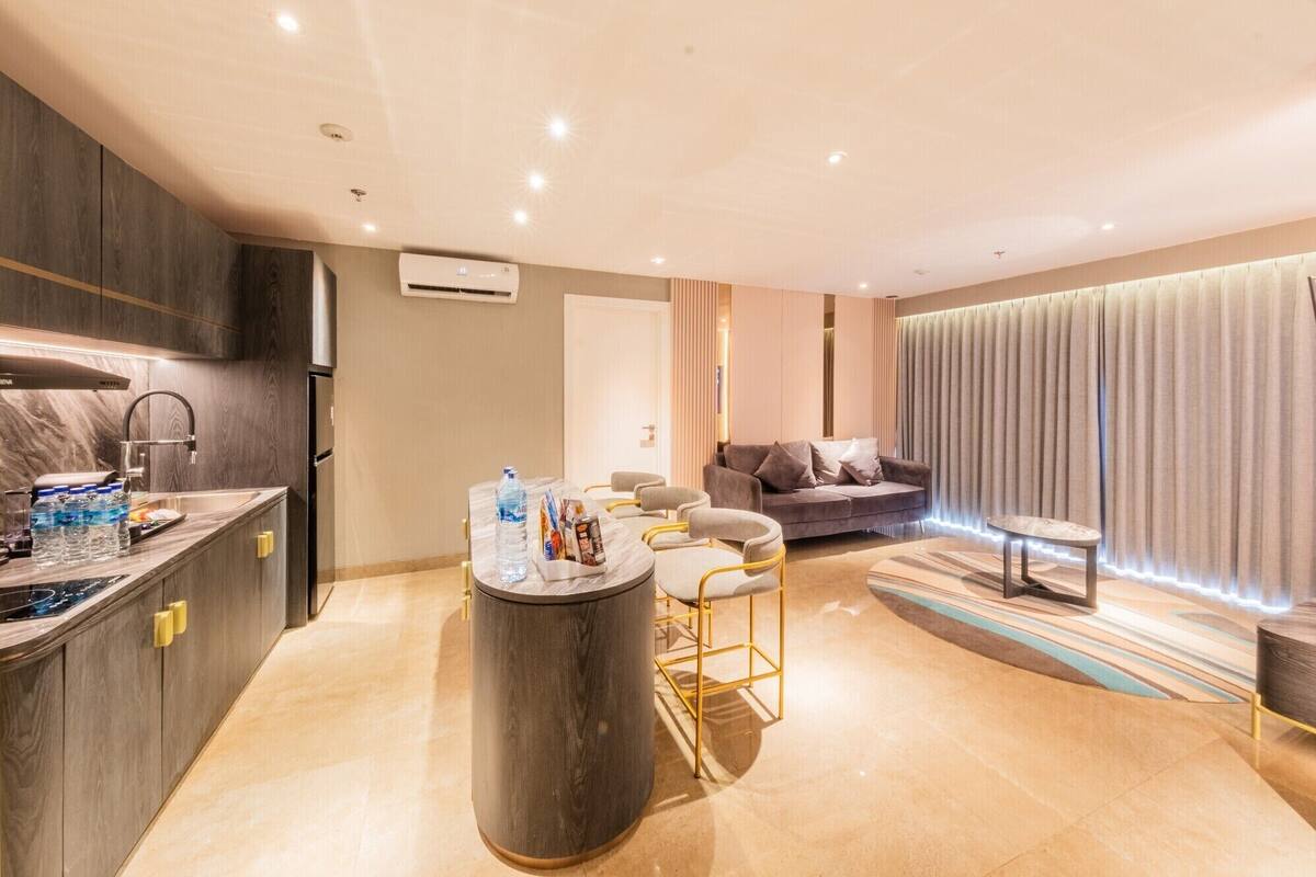 Een moderne woonkamer met een bank, een salontafel en een barruimte met een waterdispenser.