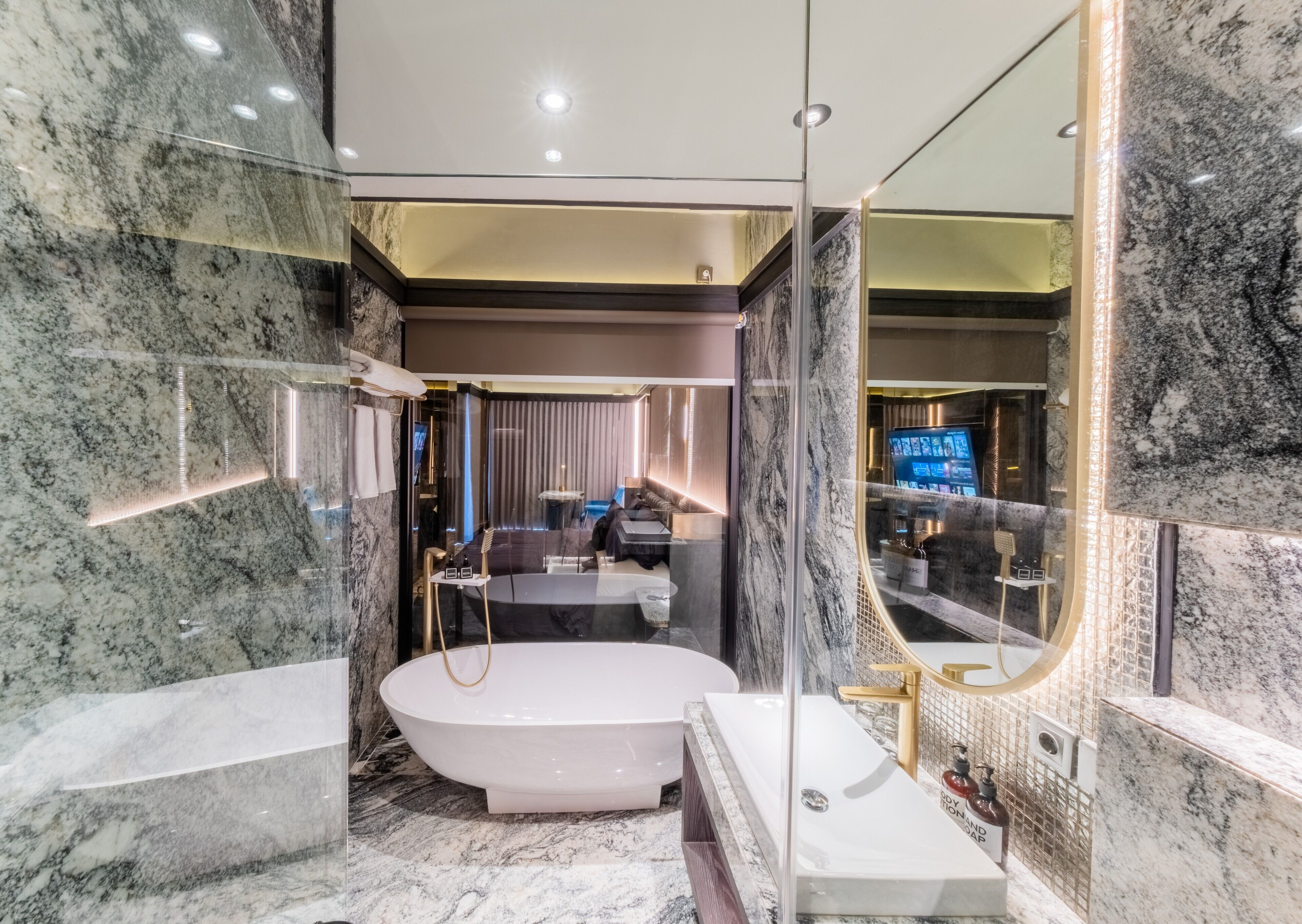 A modern bathroom with a freestanding bathtub, a separate sink, and a large mirror.