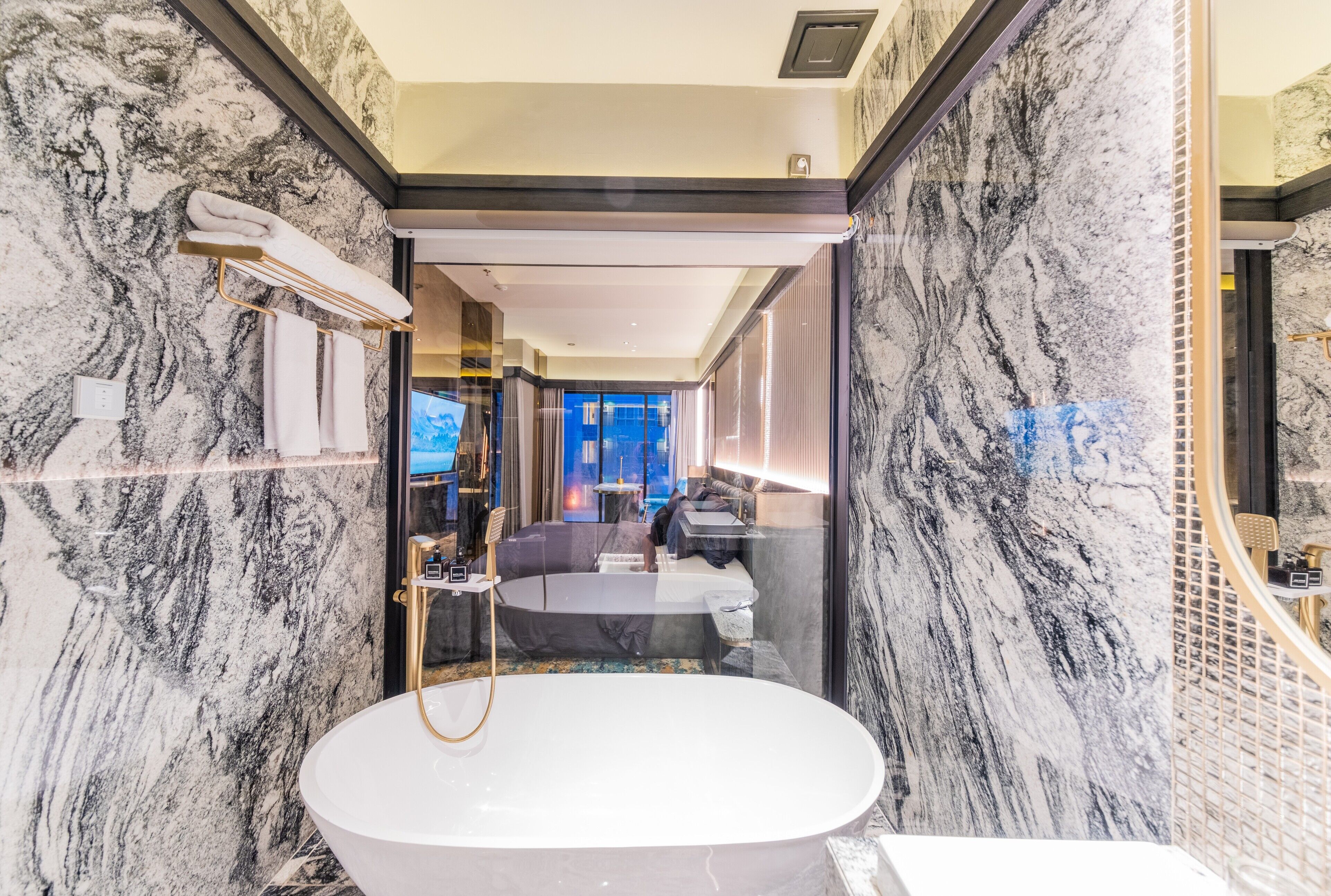 A luxurious bathroom with a large marble sink, a bathtub, and a walk-in shower.