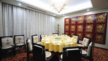 A conference room with a round table, chairs, and a chandelier.