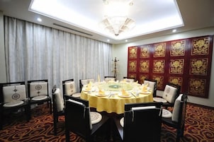 A conference room with a round table, chairs, and a chandelier.