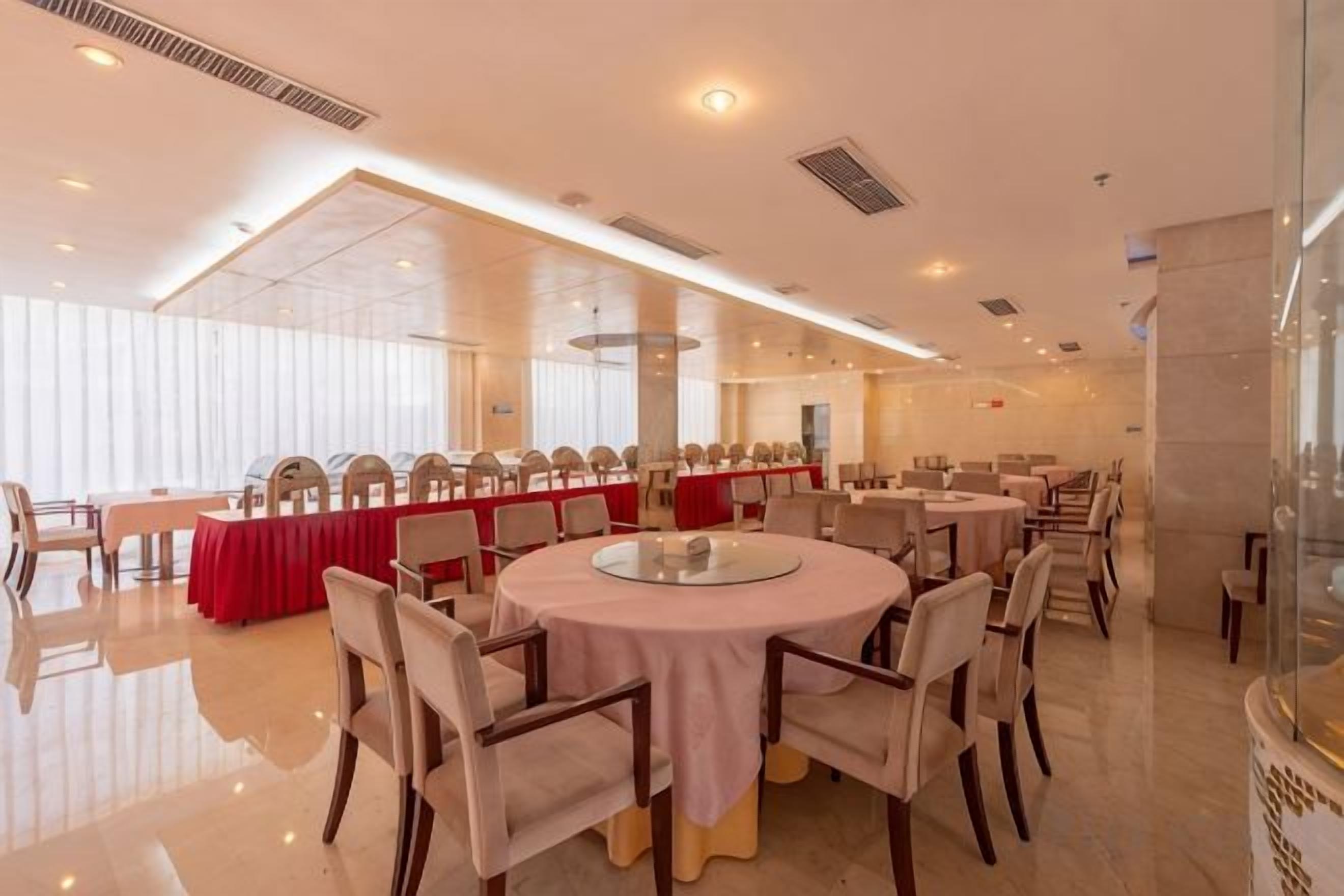 A conference room with round tables and chairs, large windows, and a modern interior design.