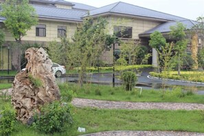 Zona residencial con un edificio grande, una carretera serpenteante y una formación rocosa.