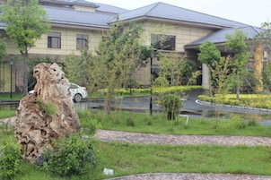 Zona residencial con un edificio grande, una carretera serpenteante y una formación rocosa.