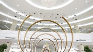 Un intérieur moderne au design circulaire, agrémenté d’un lustre et d’une composition florale.
