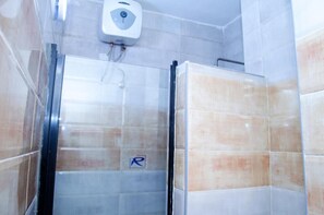 A bathroom with a glass shower enclosure, a hand dryer, and a "P" sign indicating a parking area. - Silicon Valley Resort (Enugu)