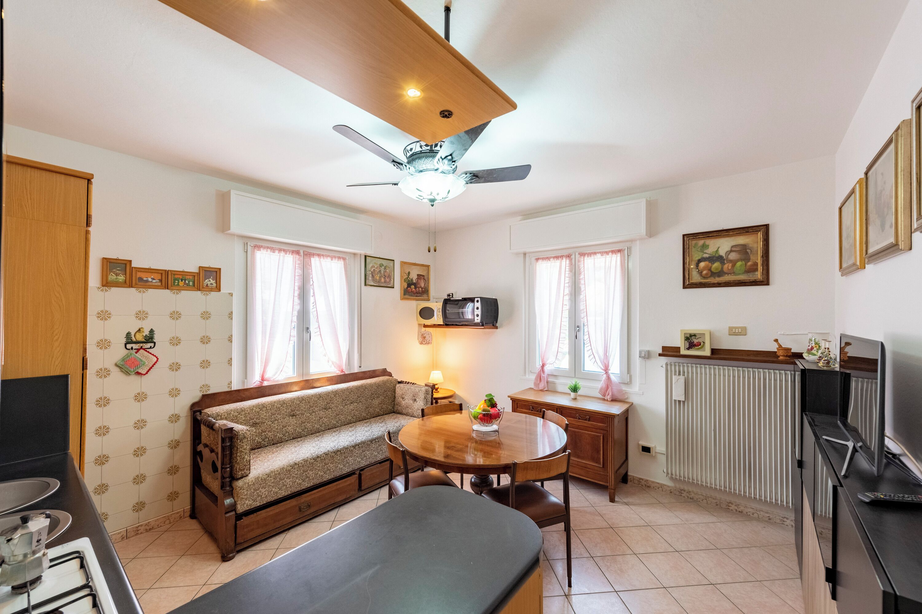 A compact living space with a sofa, dining table, and kitchenette.