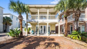 A two-story building with a covered entrance and a balcony. - Royal Palms Retreat 3 Bedroom Home by RedAwning (Panama City Beach)
