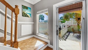 A staircase with wooden balusters leading to a landing with a view of a backyard. - Royal Palms Retreat 3 Bedroom Home by RedAwning (Panama City Beach)