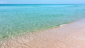 Una playa con agua turquesa cristalina y una orilla arenosa.