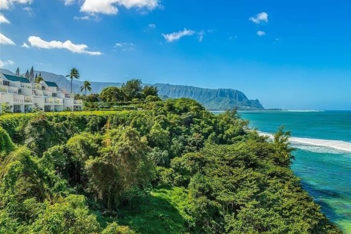 Ein Küstenhotel mit üppiger Vegetation und Meerblick.
