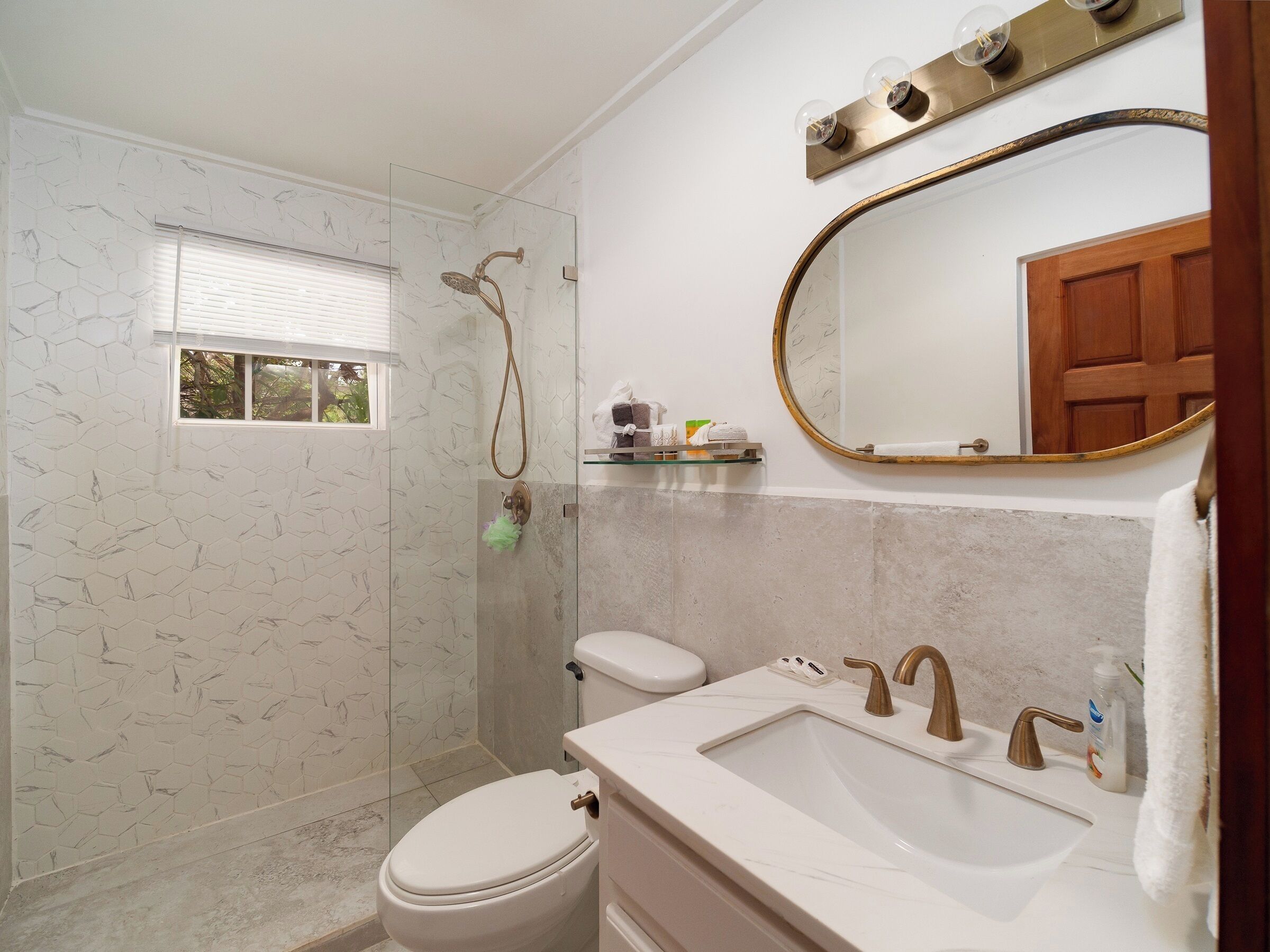 A bathroom with a shower, toilet, and sink.