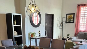 A dining area with a glass-top table, six chairs, a decorative centerpiece, and a modern ceiling fan. - NEW cozy & Spacious 5B, 3B, 1 parking close to Condado Beach (San Juan)