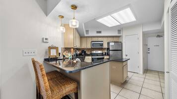A modern kitchen with a central island, built-in appliances, and pendant lighting.