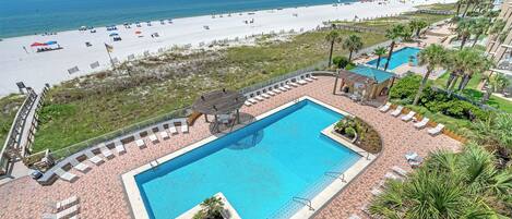 A resort with a swimming pool, beach access, and a view of the ocean.