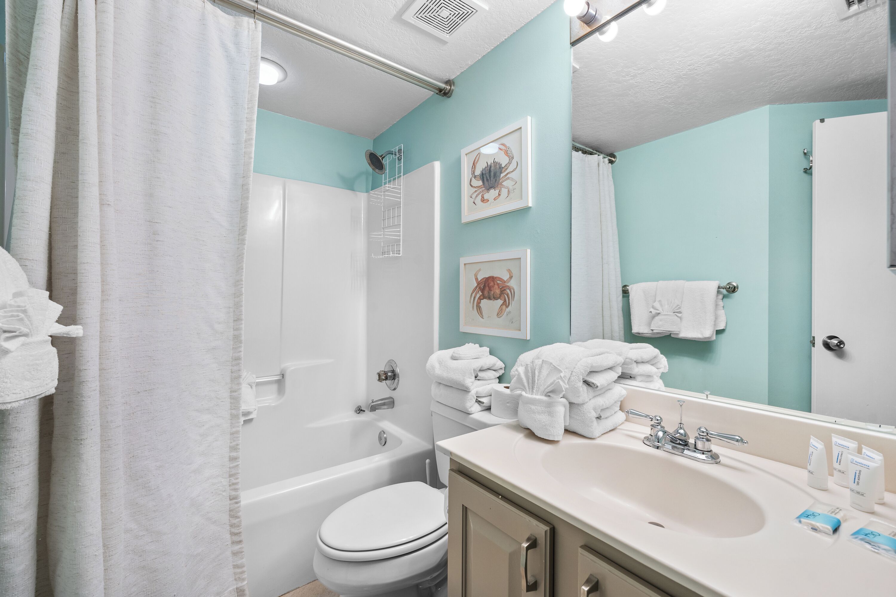 Une salle de bain avec une baignoire, des toilettes, un lavabo et un miroir.