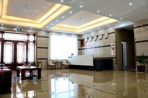 A hotel lobby with a reception desk, seating area, and a large window. - Shangzhi Longmen Hotel (Shangzhi)