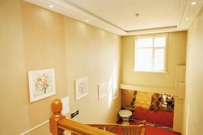 A hotel room with a staircase, a window with blinds, and a red carpeted area. - Shangzhi Longmen Hotel (Shangzhi)