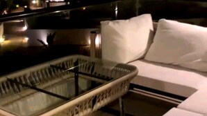 Un espace de vie moderne avec une table à plateau en verre, un canapé blanc et un radiateur blanc.