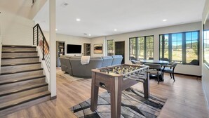 A spacious living room with a foosball table, a gray sofa, and a flat-screen TV. - Lazy Daze, Black Hills of SD (Sturgis)
