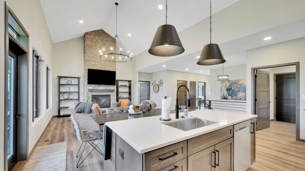A spacious kitchen with a large island, modern pendant lights, and a stone accent wall. - Lazy Daze, Black Hills of SD (Sturgis)