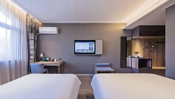 A hotel room with two beds, a desk, a TV, and a wardrobe. - Home Inn (Heyuan Railway Station) (Heyuan)