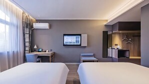 Quarto de hotel com duas camas, uma mesa, uma televisão e um guarda-roupa.