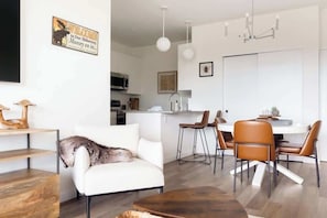 Una sala de estar moderna con un sofá, una mesa de centro y un comedor con sillas y una mesa.