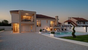 A modern two-story house with a swimming pool, a covered patio, and a well-maintained lawn. - Luxury Villa Morus with pool 50m2, gym, family, bbq (Murvica)