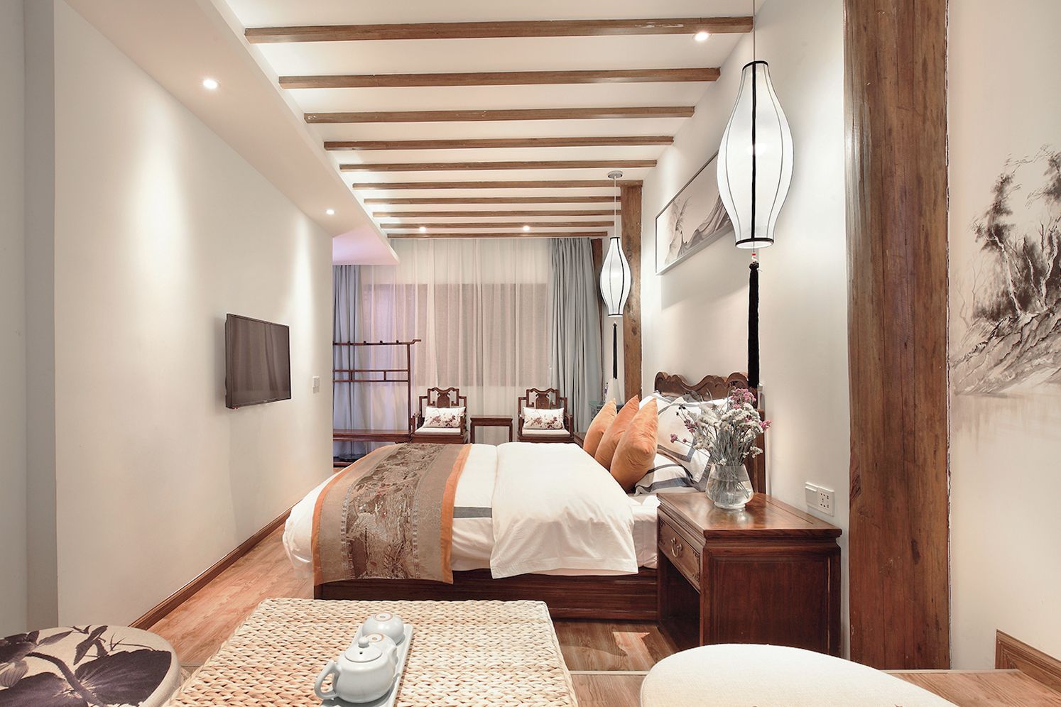 A modern bedroom with a large bed, bedside tables, a TV, and a painting on the wall.