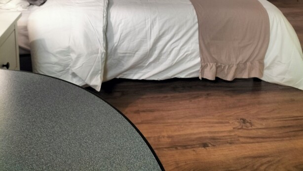 Une chambre d’hôtel moderne avec un grand lit, une table de chevet, une lampe, une chaise et un rideau.
