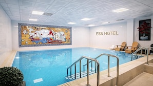 Una hall d'albergo con una grande piscina interna, un'opera d'arte in mosaico e un cartello con la scritta "ESS HOTEL".