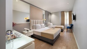 Una moderna camera d'albergo con un ampio letto, comodini, una scrivania e una sedia.