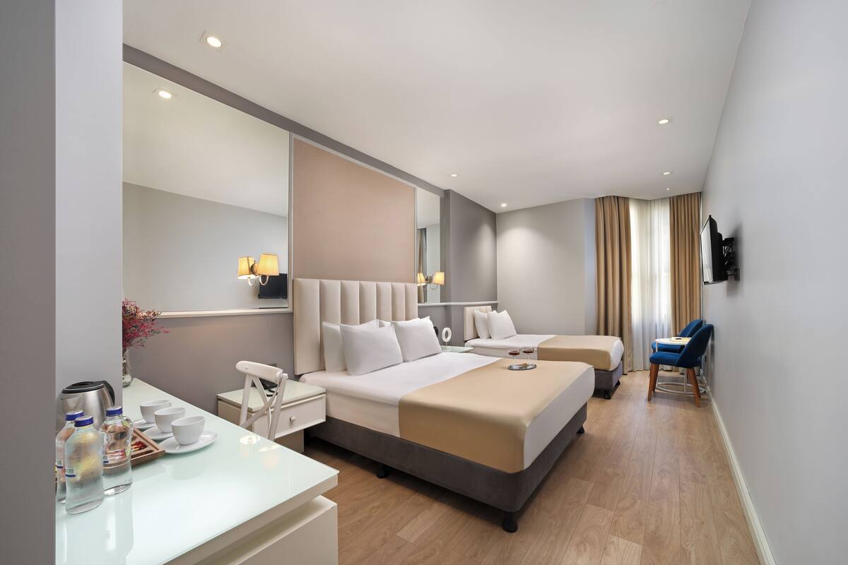 Une chambre d’hôtel moderne avec un grand lit, des tables de chevet, un bureau et une chaise.