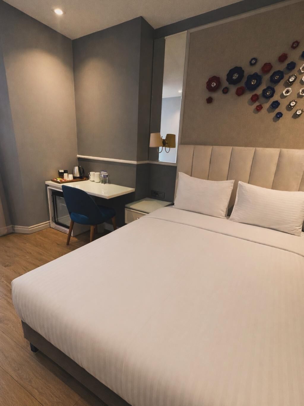 Et moderne hotelværelse med en stor seng, et skrivebord og en stol.