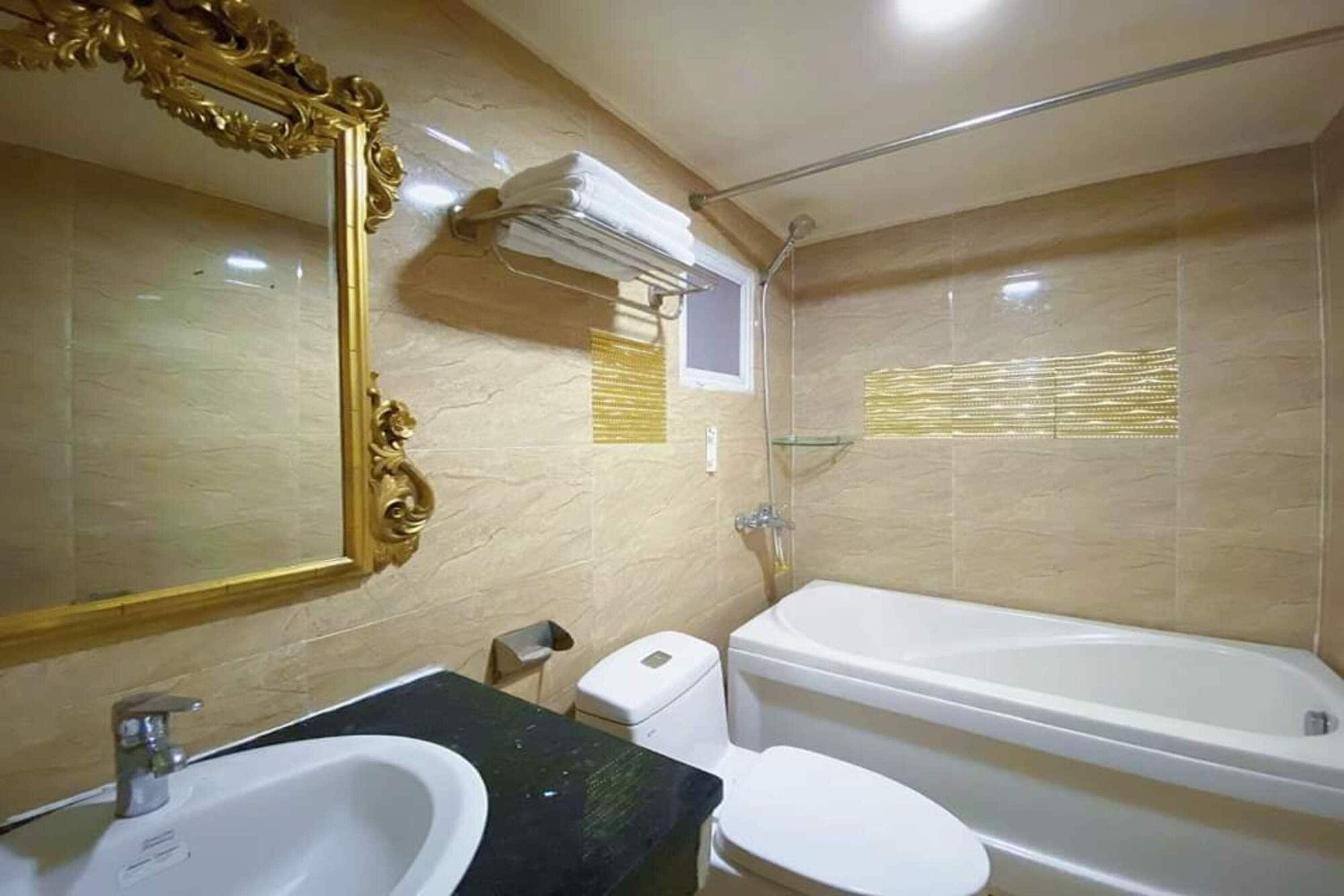 Un baño con lavamanos, inodoro y bañera.