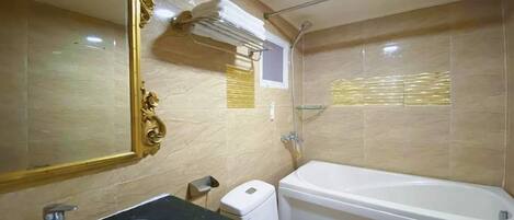 Un baño con lavamanos, inodoro y bañera.